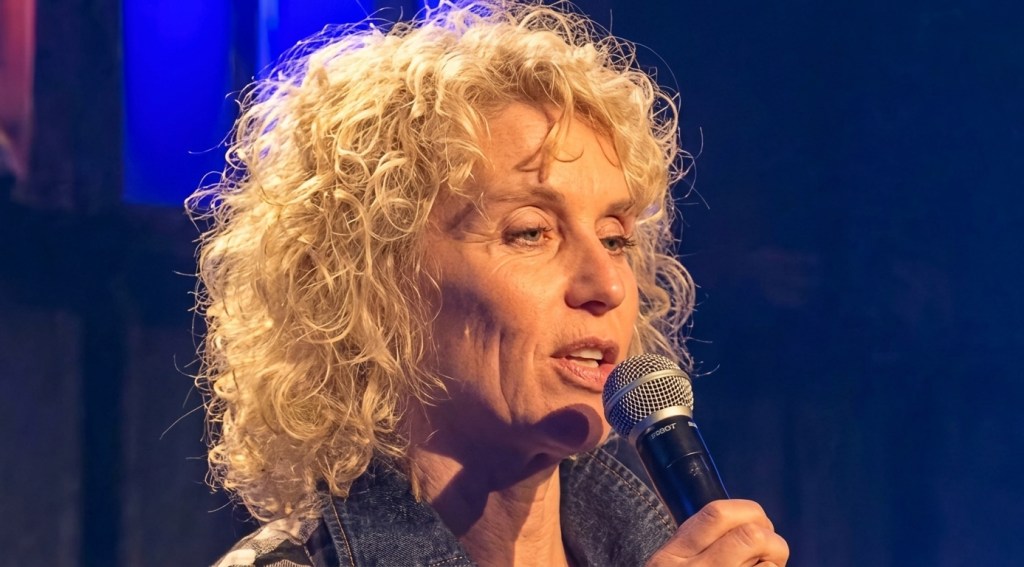 Manuela Stoerzer, Speaker and Coach speaking into a microphone at an event